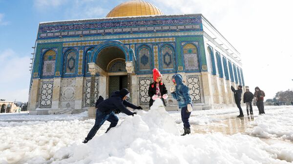Дети строят снеговика перед мечетью Купол Скалы, расположенной в Старом городе Иерусалима - اسپوتنیک ایران  