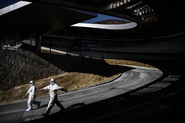 پشت صحنه بازی‌های المپیک زمستانی در پکن.دو داوطلب در حال عبوراز یکی از سازه های المپیکی. - اسپوتنیک ایران  