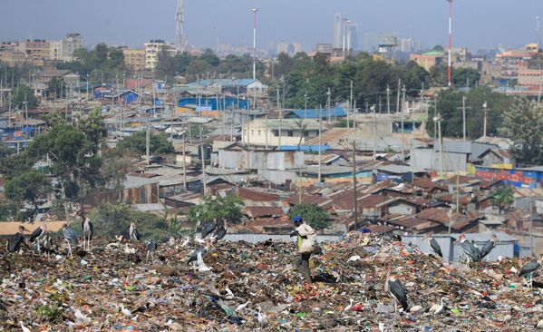 آشغال‌جمع‌کن در نزدیکی مواد پلاستیکی قابل بازیافت در محل تخلیه Dandora در حومه نایروبی، کنیا دیده می شود. - اسپوتنیک ایران  