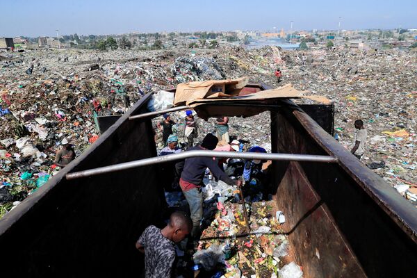 آشغال‌جمع‌کن ها در حال جستجو در میان آشغال ها  در نزدیکی مواد پلاستیکی قابل بازیافت در محل تخلیه Dandora در حومه نایروبی، کنیا دیده می شود. - اسپوتنیک ایران  