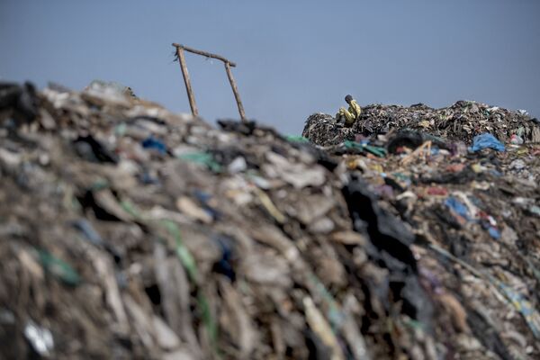 کوه پلاستیکی در نزدیکی مواد پلاستیکی قابل بازیافت در محل تخلیه Dandora در حومه نایروبی، کنیا دیده می شود. - اسپوتنیک ایران  