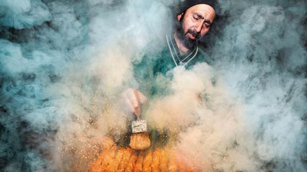 عکسی از یک فروشنده غذای خیابانی که در حال پخت کباب روی اجاق دودی است در مسابقه عکاسی بانوی صورتی 2022
 - اسپوتنیک ایران  
