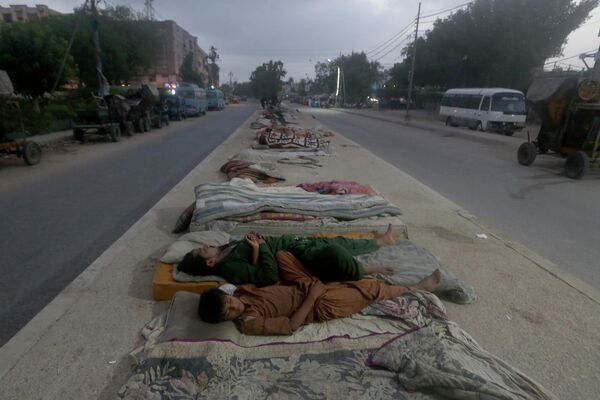 رویدادهای هفته به روایت تصویر.استراحت کارگران در وسط خیابان در کراچی. - اسپوتنیک ایران  