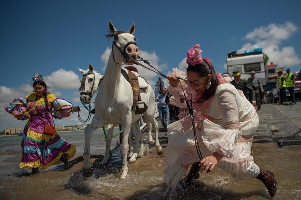 رویدادها و حوادث هفته گذشته از نگاه تصویر.زائران اسپانیا در حال عبور از رودخانه برای رسیدن به معبد دونانا. - اسپوتنیک ایران  