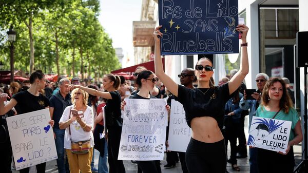 Танцовщицы кабаре Lido и профсоюзные активисты проводят демонстрацию, пытаясь спасти свои рабочие места, на Елисейских полях в Париже - اسپوتنیک ایران  