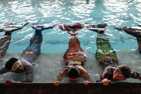 شرکت کنندگان برنامه آموزش شنای پری دریایی در آفریقای جنوبی در حال انجام تمرینات روزانه. - اسپوتنیک ایران  