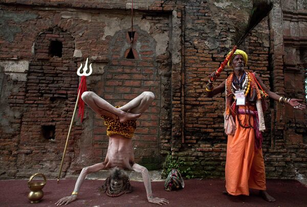 روز جهانی یوگا 21 ماه ژوئن برگزار می شود.یک مرد مقدس هندی سادو یا هندو، در سمت چپ، در معبد کاماخیا در طول جشنواره آمبوباچی، در گائوهاتی هند، یوگا انجام می دهد. - اسپوتنیک ایران  