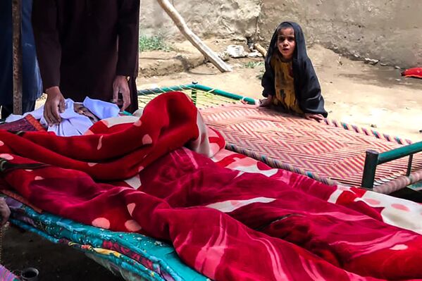 جسد مرد افغان که در زلزله ۲۲ ژوئن ۲۰۲۲ در ولسوالی گایان، ولایت پکتیکا کشته شد، پیچیده در پتو، پیش از مراسم خاکسپاری . - اسپوتنیک ایران  