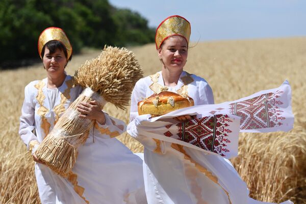 مراسم آغاز کارزار برداشت به عنوان بخشی از &quot;روز مزرعه جمهوری - 2022&quot; در منطقه ولودارسکی جمهوری خلق دونتسک.زنان در لباس ملی جمهوری و دسته های گندم. - اسپوتنیک ایران  