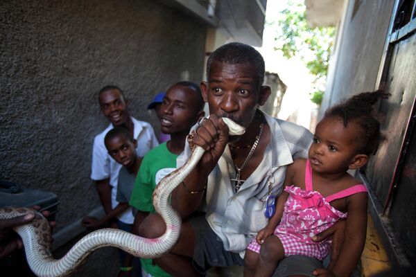 بوسیدن مار به عنوان شانس آوردن در هائیتی.روز جهانی مار در 16 جولای برگزار می شود.  در بین 3500 گونه مار مختلف در جهان، تقریبا 600 مورد آن ها سمی هستند. طبق اطلاعات سازمان سلامت جهانی فقط 200 نوع از آن ها زندگی انسان ها را تهدید می کنند. - اسپوتنیک ایران  
