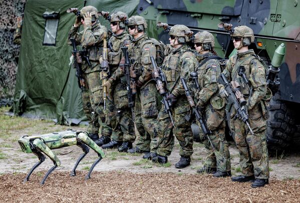 یک سگ ربات چند منظوره به نام &quot;ولفگانگ&quot; از نیروهای مسلح آلمان (بوندسوهر) در مقابل سربازان آلمانی هنگام ارائه این دستگاه در حالی که وزیر دفاع آلمان از واحد دیجیتالی سازی عملیات زمینی نیروهای مسلح آلمان در 11 ژوئیه 2022 بازدید می کند - اسپوتنیک ایران  