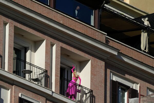 یک زن قبل از شروع مجموعه مد لباس زنانه پاییز-زمستان 2022-2023 زنان والنتینو که در پله های اسپانیایی رم، جمعه، 8 ژوئیه 2022 رونمایی شد، روی بالکن ژست می گیرد - اسپوتنیک ایران  