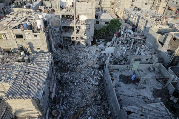 پس از حملات هوایی اسرائیل در رفح در جنوب نوار غزه، امدادگران در میان آوارهای یک ساختمان در حال جستجو هستند. - اسپوتنیک ایران  
