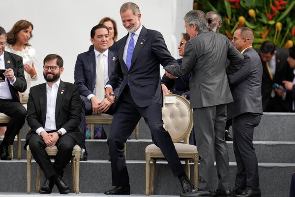 رئیس جمهور اکوادور، گیلرمو لاسو، در سمت راست، دست پادشاه اسپانیا فیلیپه را  گرفته است. گابریل بوریک، رئیس جمهور شیلی، سمت چپ، در جریان مراسم سوگند گوستاوو پترو رئیس جمهور در بوگوتا، کلمبیا نشسته است. - اسپوتنیک ایران  