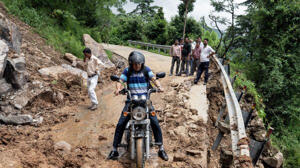 Мотоциклист пытается проехать через перекрытую оползнем дорогу в Дхарамсале, штат Химачал-Прадеш, Индия - اسپوتنیک ایران  
