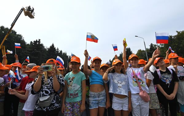 دانش آموزان مدرسه مراسم پرچم سه رنگ به مساحت 1000 متر مربع را در روز پرچم ملی روسیه در موزه پیروزی در مسکو تماشا می کنند. - اسپوتنیک ایران  