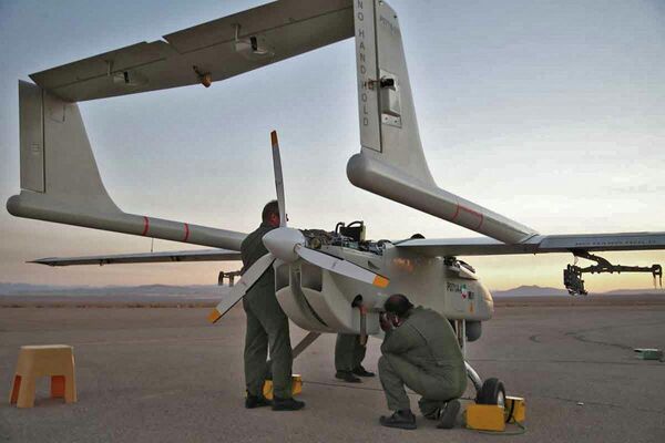 تصویر ارائه شده توسط ارتش ایران در ۲۴ آگوست ۲۰۲۲، تکنسین‌ها در حال بررسی یک هواپیمای بدون سرنشین نظامی (پهپاد) در باند فرودگاه در یک مانور دو روزه پهپادی در مکانی نامعلوم در ایران - اسپوتنیک ایران  