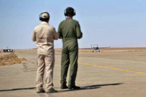 تصویر ارائه شده توسط ارتش ایران در ۲۴ آگوست ۲۰۲۲، تکنسین‌ها در حال کار با هواپیماهای بدون سرنشین نظامی (پهپاد) در باند فرودگاه در یک مانور دو روزه پهپادی در مکانی نامعلوم در ایران - اسپوتنیک ایران  