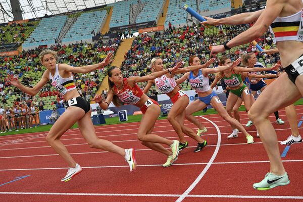 دوندگان باتوم را در طول مسابقات رله 4×400 متر زنان در طول مسابقات قهرمانی دو و میدانی اروپا در استادیوم المپیک مونیخ تحویل می‌دهند. - اسپوتنیک ایران  