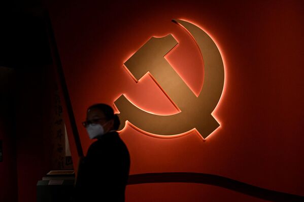 یک زن در مقابل نشان حزب کمونیسم در نمایشگاهی با موضوع حزب کمونیست چین در موزه ملی پکن  - اسپوتنیک ایران  