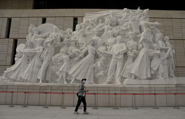 مردی در 4 سپتامبر 2022 در مقابل یک بنای تاریخی در موزه حزب کمونیست چین در پکن قدم می زند.  - اسپوتنیک ایران  