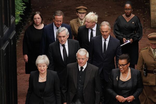 ردیف جلو از چپ به راست، نخست وزیران سابق بریتانیا ترزا می، جان میجر، و بارونس اسکاتلند، (ردیف دوم از چپ به راست) نخست وزیران سابق بریتانیا، گوردون براون، تونی بلر، (ردیف سوم از چپ به راست) نخست وزیران سابق بریتانیا دیوید کامرون و بوریس جانسون. - اسپوتنیک ایران  