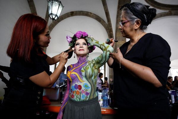 نقاشان در حال نقاشی روی بدن زنی هستند که مبتلا به سرطان سینه شده بود. - اسپوتنیک ایران  