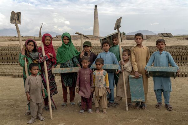 Афганские дети, работающие на кирпичном заводе, позируют для фотографии на окраине Кабула, Афганистан - اسپوتنیک ایران  