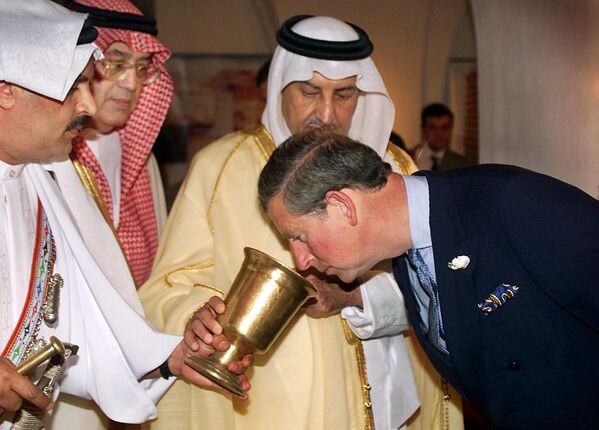 روز جهانی قهوه.پرنس چارلز در حال بوئیدن قهوه در دست پرنس سعودی خلید الفیصل السعود. - اسپوتنیک ایران  