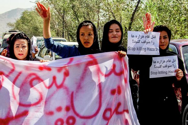 زنان افغانستانی یک روز پس از حمله انتحاری در مرکز آموزشی دشت برچی در کابل در 1 اکتبر 2022 در جریان اعتراضی که آن را &quot;نسل کشی هزاره ها متوقف کنید&quot; پلاکاردها و شعار سر می دهند. - اسپوتنیک ایران  