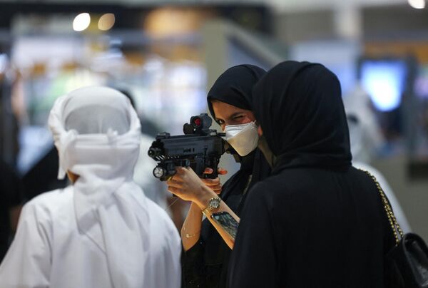 یک بازدیدکننده تفنگی را در نمایشگاه بین‌المللی شکار و سوارکاری ابوظبی (ADIHEX) در پایتخت امارات در 1 اکتبر 2022 امتحان می کند - اسپوتنیک ایران  