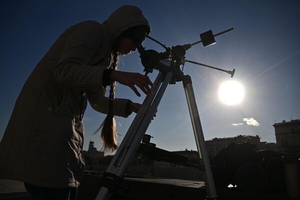 دختری از طریق تلسکوپ خورشید گرفتگی جزئی را در مسکو تماشا می کند. - اسپوتنیک ایران  