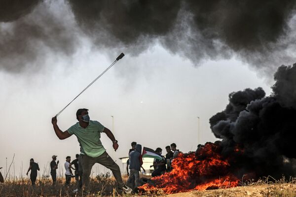 یک معترض فلسطینی در جریان درگیری با نیروهای اسرائیلی پس از تظاهرات در امتداد مرز با اسراییل، غزه - اسپوتنیک ایران  