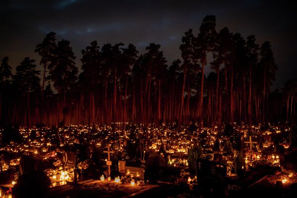 روشن کردن شمع در روز مقدسین در گورستانی در ویلنوس لیتوانی، 1 نوامبر 2022 - اسپوتنیک ایران  