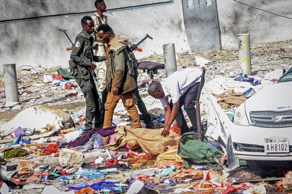 امدادگران و نیروهای امنیتی در کنار اجساد قربانیان انفجار حودروی بمب گذاری شده در موگادیشو، 29 اکتبر 2022 - اسپوتنیک ایران  