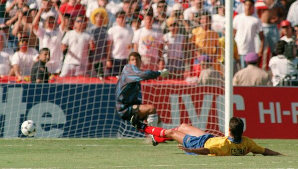 عکس مورخ 22 ژوئن 1994، مدافع کلمبیا، آندرس اسکوبار (راست) را نشان می دهد که در زمین دراز کشیده است و در بازی جام جهانی 94 ، ضربه جان هارکز از ایالات متحده را به سمت دروازه خود وارد می کند. این همان صحنه ای است که او گل به خودی مقابل آمریکا را وارد دروازه تیم خودش یعنی کلمبیا می کند، اتفاقی که باعث شد او 10 روز بعد به قتل برسد. - اسپوتنیک ایران  