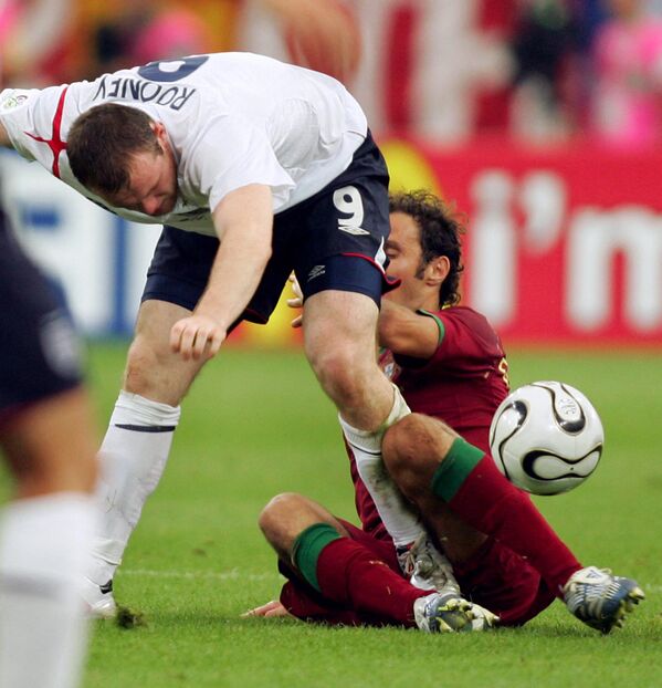 مهاجم انگلیسی وین رونی (چپ) در بازی فوتبال یک چهارم نهایی جام جهانی 2006، انگلستان مقابل پرتغال، 1 ژوئیه 2006 در استادیوم گلزنکرخن، بر کشاله ران مدافع پرتغالی ریکاردو کاروالیو زد. - اسپوتنیک ایران  