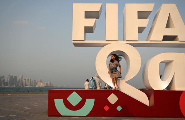 عکس گرفتن در کنار نشان فیفا در زمان برگزاری مسابقات جام جهانی فوتبال در دوحه. - اسپوتنیک ایران  