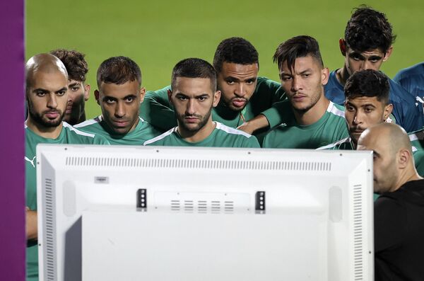 تیم مراکش در  یک  تمرین در «الدحیل اس سی» در دوحه به تماشای تلویزیون ایستاده‌اند. - اسپوتنیک ایران  