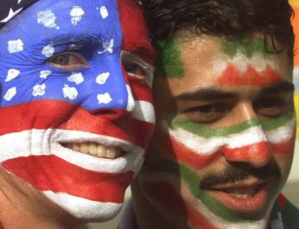 مایک ماسکروپ، سمت چپ، از اورنج کانتی، کالیفرنیا، با امیر سیددوست، یک هوادار ایرانی مقیم هلند در خارج از استادیوم گرلین در لیون یکشنبه، 21 ژوئن 1998، قبل از شروع مسابقه فوتبال آمریکا و ایران در جام جهانی، عکس می‌گیرد. - اسپوتنیک ایران  