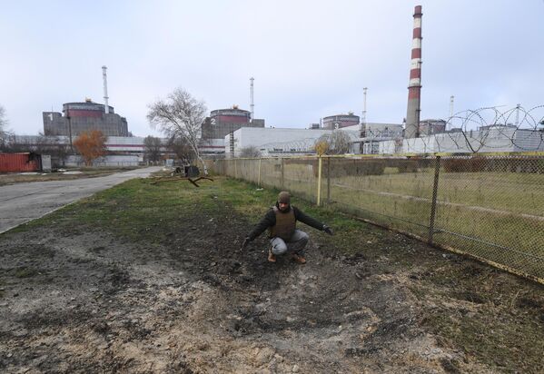 .کارمند &quot;روس انرگو اتم&quot;، دیمیتری شوچنکو در کنار گودالی که پس از انفجار خمپاره در منطقه نیروگاه هسته ای زاپاروژایا ایجاد شده است،پس از گلوله باران اخیر نیروهای مسلح اوکراین - اسپوتنیک ایران  