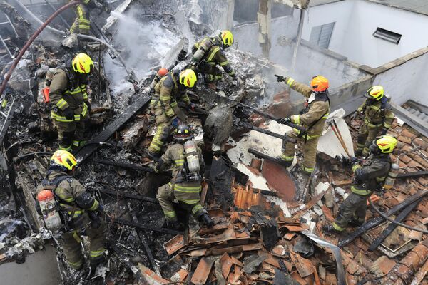 آتش نشانان در محل سقوط هواپیمای کوچکی که در منطقه مسکونی مدلین، کلمبیا، در روز دوشنبه، بر روی خانه ها سقوط کرد - اسپوتنیک ایران  