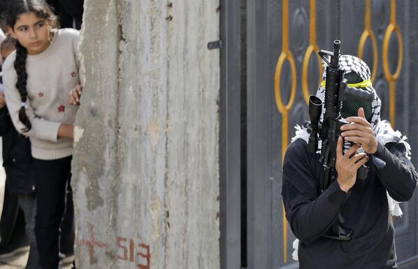 مردان مسلح فلسطینی در مراسم تشییع جنازه رائد الناسان، 21 ساله که روز گذشته در جریان درگیری با نیروهای اسرائیلی در روستای المغایر در 30 نوامبر 2022 کشته شد - اسپوتنیک ایران  