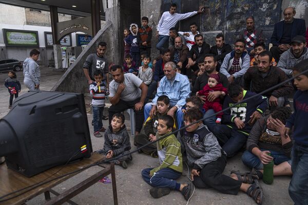 فلسطینی ها در حال تماشای پخش زنده بازی فوتبال گروه H جام جهانی بین کره جنوبی و غنا را که در قطر، در خیابان شهر غزه، دوشنبه، 28 نوامبر 2022 - اسپوتنیک ایران  