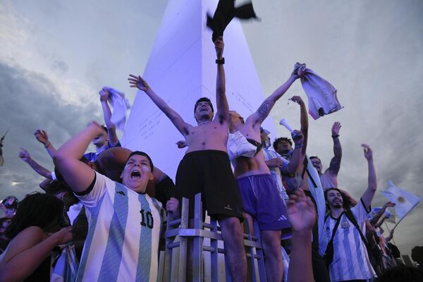 هواداران فوتبال آرژانتین، چهارشنبه، 30 نوامبر 2022، در نزدیکی ابلیسک در بوئنوس آیرس، آرژانتین، بازی برد تیمشان مقابل لهستان در جام جهانی را جشن می گیرند. - اسپوتنیک ایران  