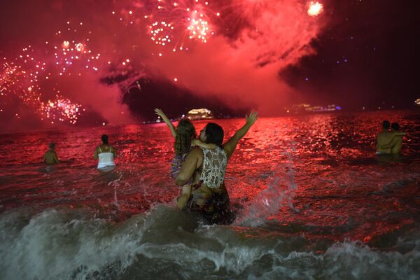 آتش بازی برای جشن سال نو از قایق ها در ساحل کوپاکابانا در ریودوژانیرو، برزیل، در 1 ژانویه 2017 پرتاب می شود. (عکس از FABIO TEIXEIRA / AFP) - اسپوتنیک ایران  