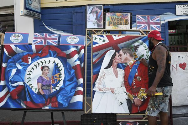 هنرمندی تصویری از ویلیام شاهزاده انگلیس و همسرش کاترین را در یکی از خیابان‌های شهر بلیز ترسیم می‌کند. - اسپوتنیک ایران  