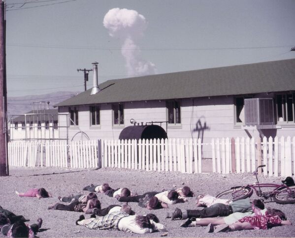دانش آموزان یک مدرسه در حال آموزش اقدامات محافظتی در برابر انفجار یک بمب اتمی در حالت واقعی انفجار. این عکس در شهر ایندیان اسپرینگز (نوادا)، واقع در 40 کیلومتری کانون انفجار یک بمب هوایی 31 کیلوتنی گرفته شده است. 22 آوریل 1952 ساعت 09:30. - اسپوتنیک ایران  