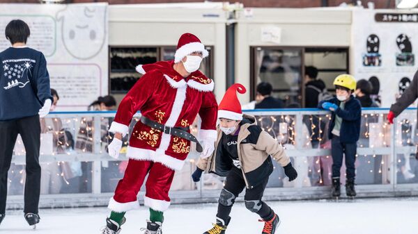 Люди в рождественской одежде катаются на коньках на катке в Йокогаме - اسپوتنیک ایران  