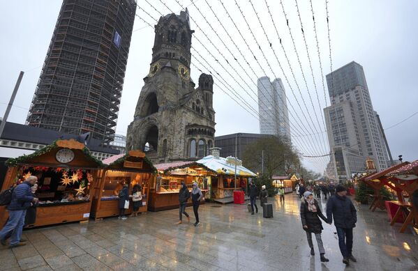 مردم از بازار کریسمس در میدان &quot;بریت شاید&quot; نزدیک کلیسای یادبود قیصر ویلهلم در برلین، آلمان، بازدید می کنند. - اسپوتنیک ایران  
